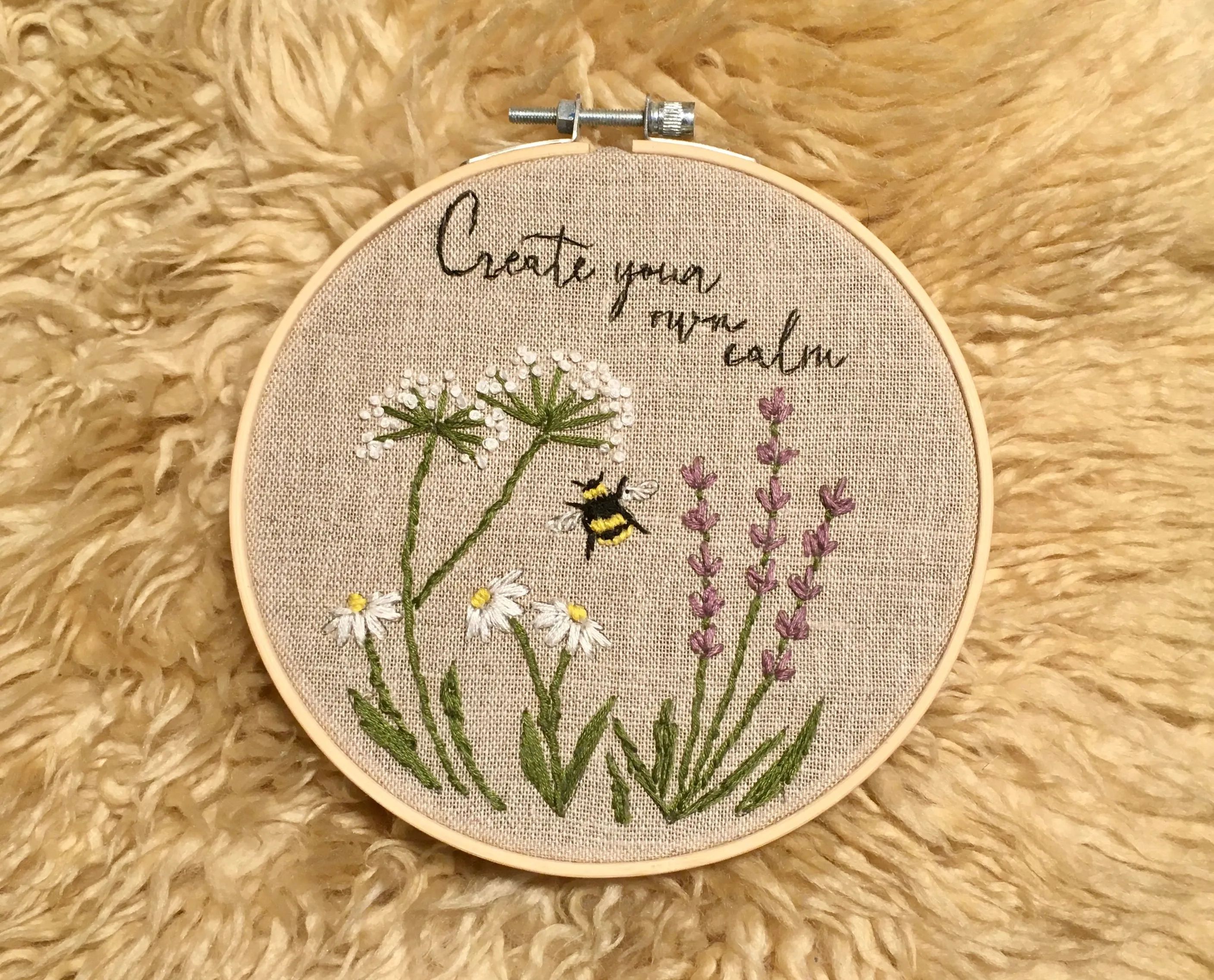 cross-stitch pattern of a garden with the text 'create your own calm'